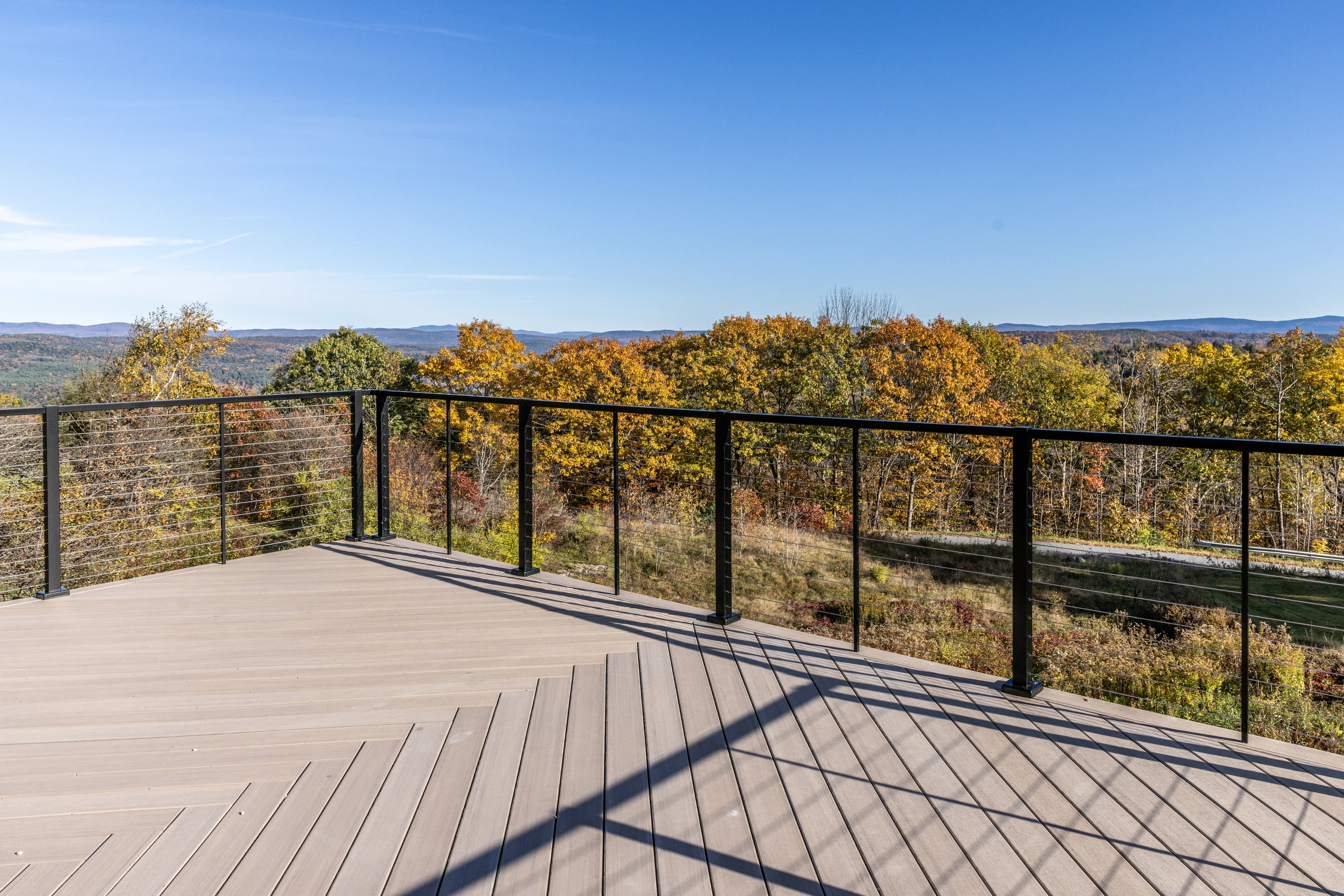 Deck with dark metal railings overlooking autumn hills in Quechee.