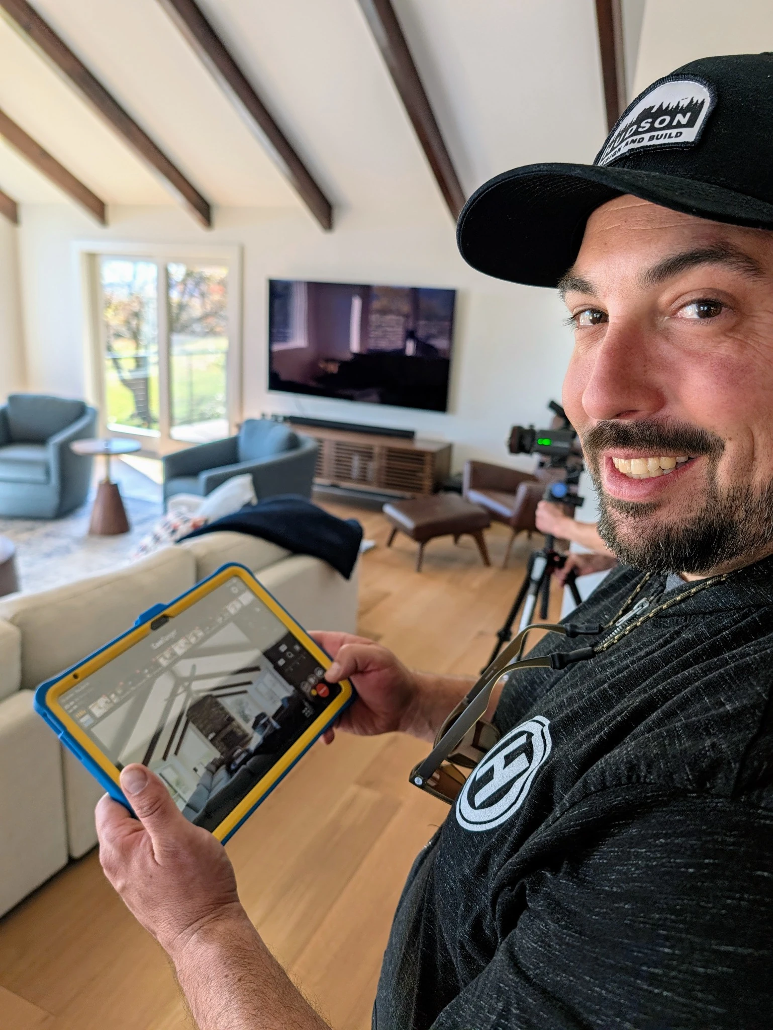 A smiling Hudson team member holding a tablet during photography of a completed home.