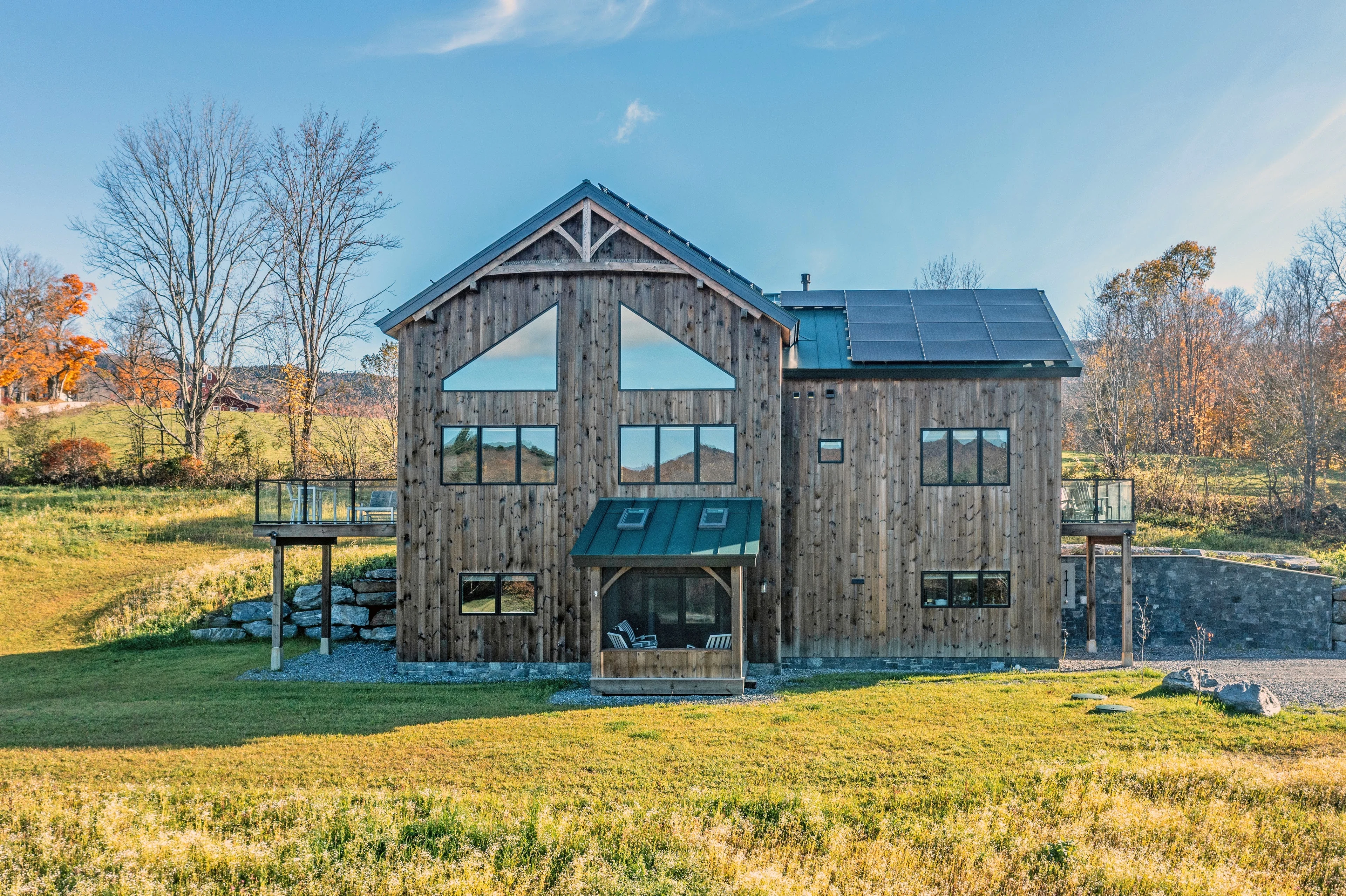 Timber frame home with tall gable windows, natural wood siding and a standing-seam roof in Rochester, Vermont.