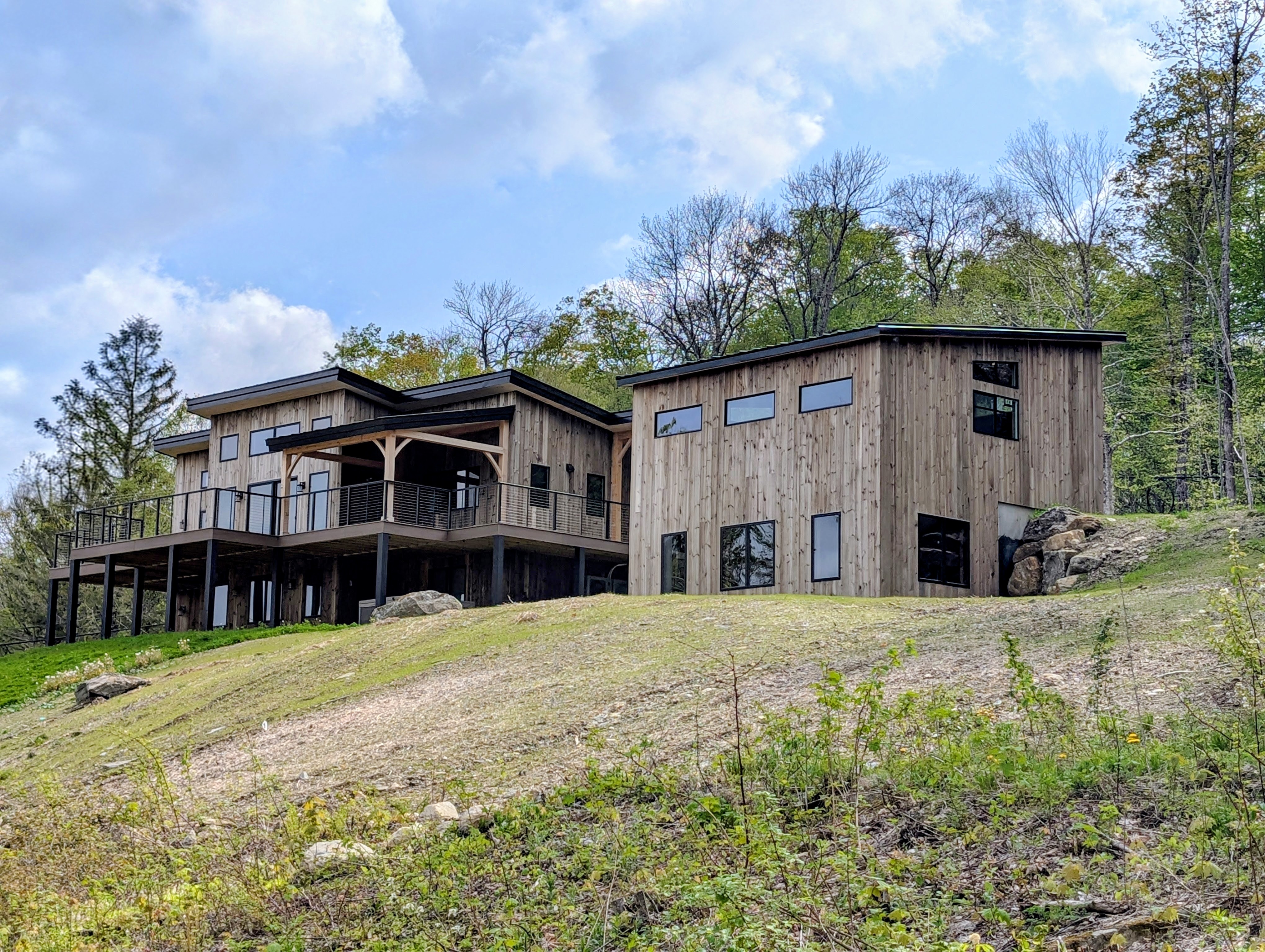 Original photograph of the Killington timber frame home, covered deck and garage, with the existing early-season lawn and trees.