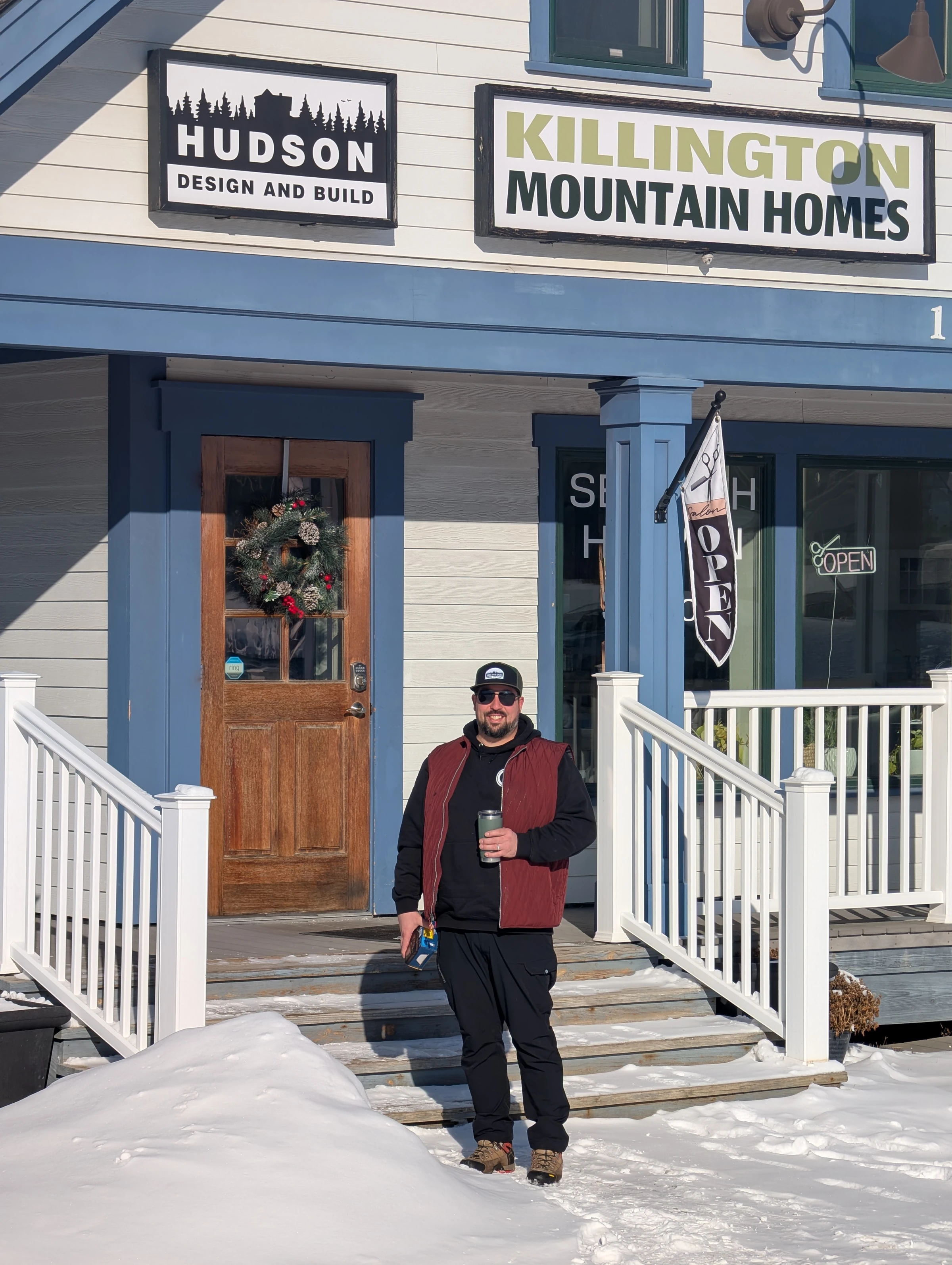 Hudson Design and Build and Killington Mountain Homes signs side by side above the Killington office entrance.