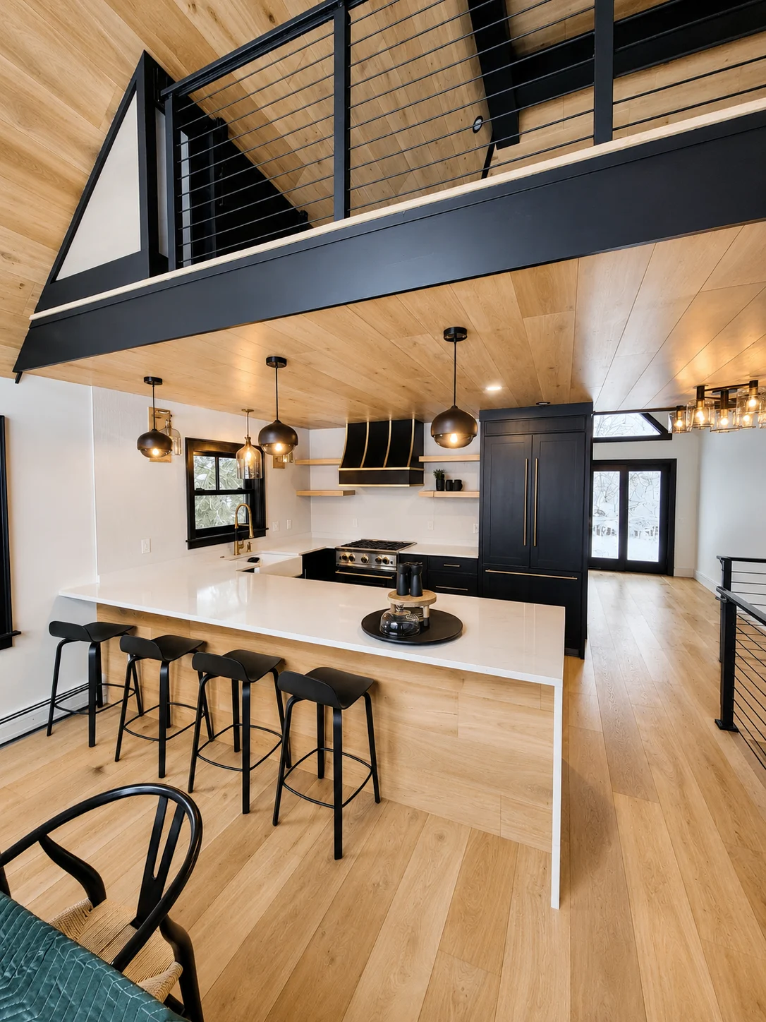 Modern kitchen with black cabinetry, a pale island and warm wood finishes in a Hudson Design and Build renovation on South Street, Woodstock, Vermont.