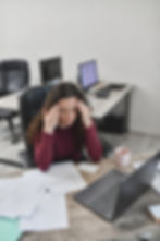 Neurodivergent individual experiencing executive functioning challenges while feeling overwhelmed by task overload at a cluttered desk with work materials, illustrating ADHD paralysis, organization difficulties, and difficulty initiating tasks