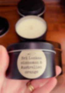 A black tin being held up to show the size of the tin fits into a hand label reads Sri Lankan cinnamon & Australian orange