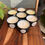 Thumbnail: a group of soy wax white candles with the lids off the tins showing clean wicks and variety of smells