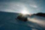 Snowmobiler riding across alpine slope at sunset in the Bighorn Mountains, Wyoming