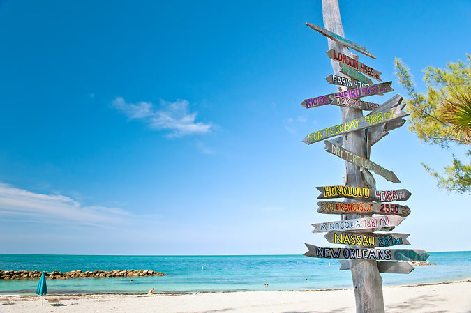 mileage signpost on key west florida beach, with copy space. this is updated; Salt Island Airways, Flights from Marco Island and Palm Beach to Key West