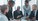 5 professionally dressed colleagues discussing business with smiles on their faces while grey laptop is opened