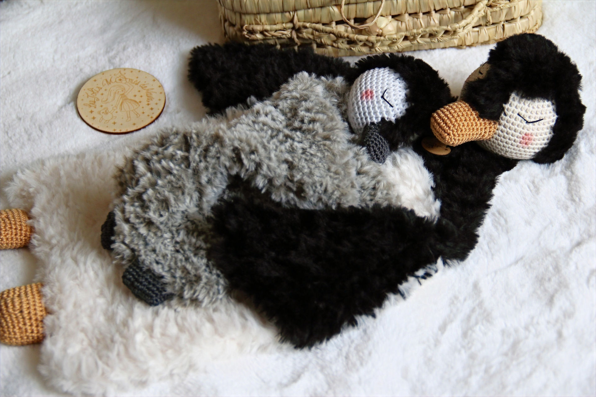 un doudou pingouin qui câline son bébé