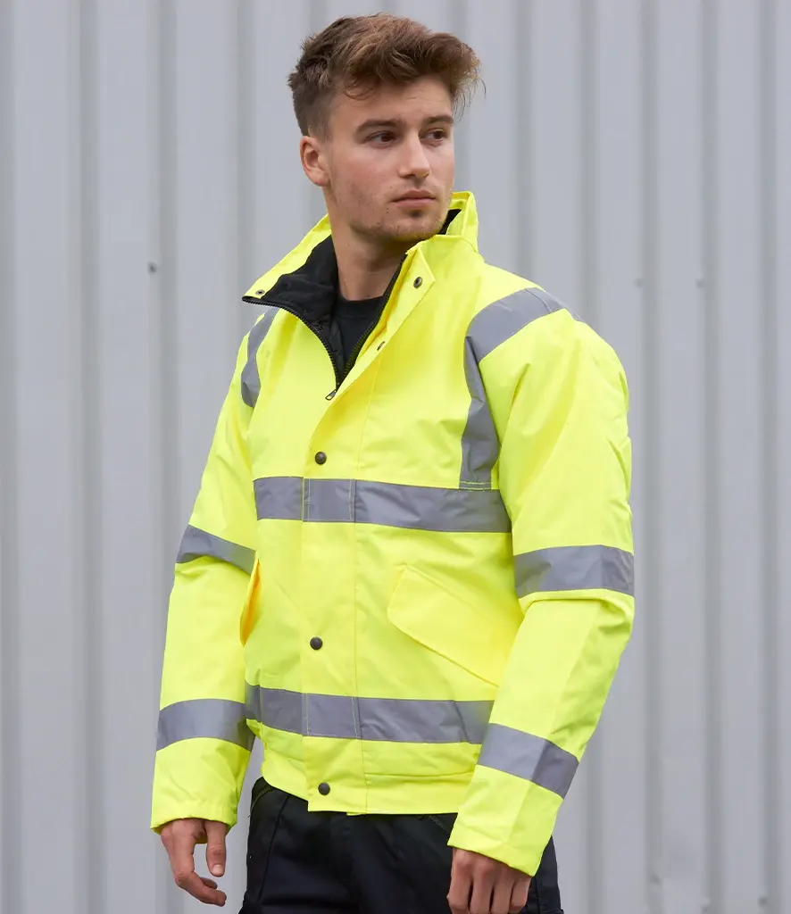 Man wearing a bright yellow work jacket with reflective stripes. The Workwear Hub.