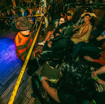 Buster Price blindfolded. He is separated from the audience by a police caution tape line.