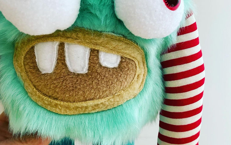 Close up of green monster with stripy arms