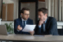 Serious young man supervisor analyse financial report of responsible worker pay attention