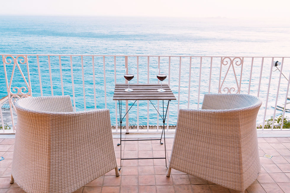 two glasses of wine on table overlooking Amalfi Coast