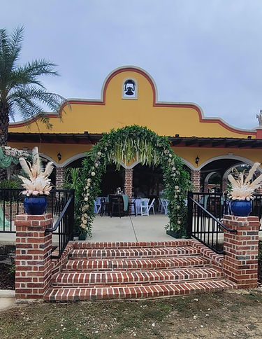 Flowered archway leading to wedding reception in El Ruedo open-air pavilion at La Hacienda Venue Mississippi