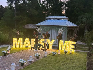Marry Me sign in lights with man proposing at La Hacienda Venue