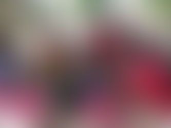 路上の木陰で、色鮮やかな服の女性たちが集まり、保健員が座った女性の血圧を測っている。和やかな雰囲気。