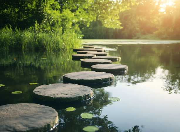 Stepping stones across calm water symbolizing progress and personal growth through life coaching