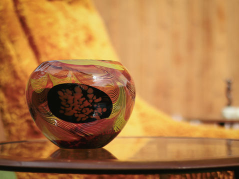 Decorative glass vase on a reflective surface.