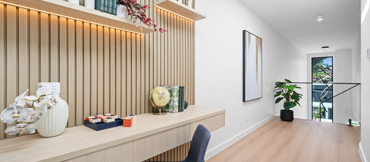Upper-level study with timber slat wall, integrated desk, skylight and connection to the central void.