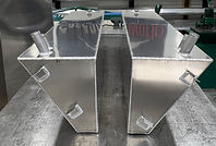 Matching port and starboard marine fuel tanks showing angled inner walls and welded mounting tabs.