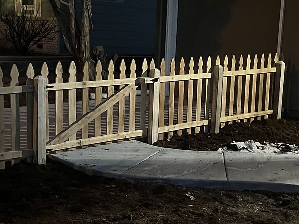 Short decorative picket fence, photographed at night.