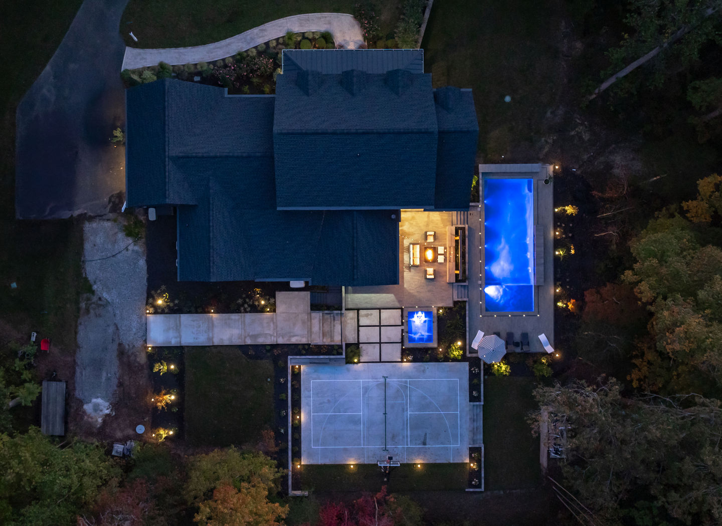 an aerial view of a house with a basketball court and pool