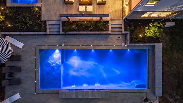overhead hi res photo of vb patios pool with recessed lighting surrounding the pool. Paver pool deck