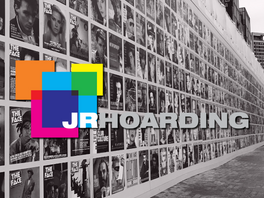A black and white photo showing a hoarding styled with magazine covers, overlayed with JR Hoarding Logo
