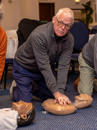 Man being taught how to perform CPR