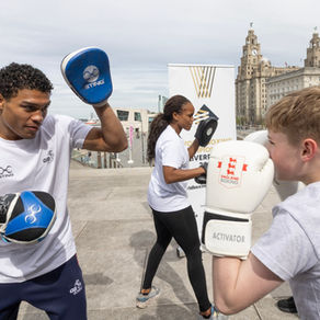 Odel Kamara practicing boxing with a young man
