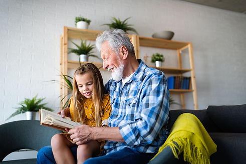 happy-little-girl-with-grandfather-reading-story-ZPJPMAS.jpg