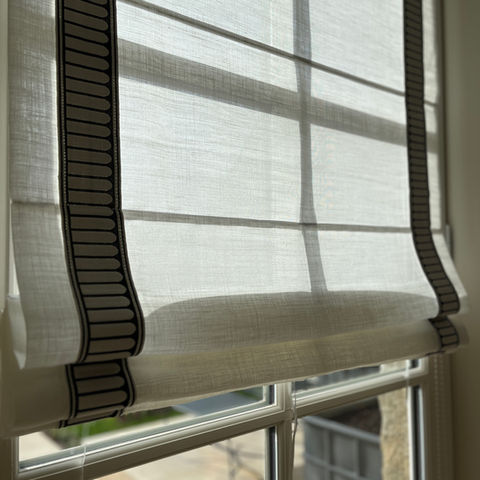 Détail d'un store bateau en voile de lin avec passementerie appliquée.