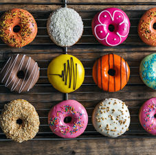 Brightly lit donut shop with a display of assorted donuts in various flavors.