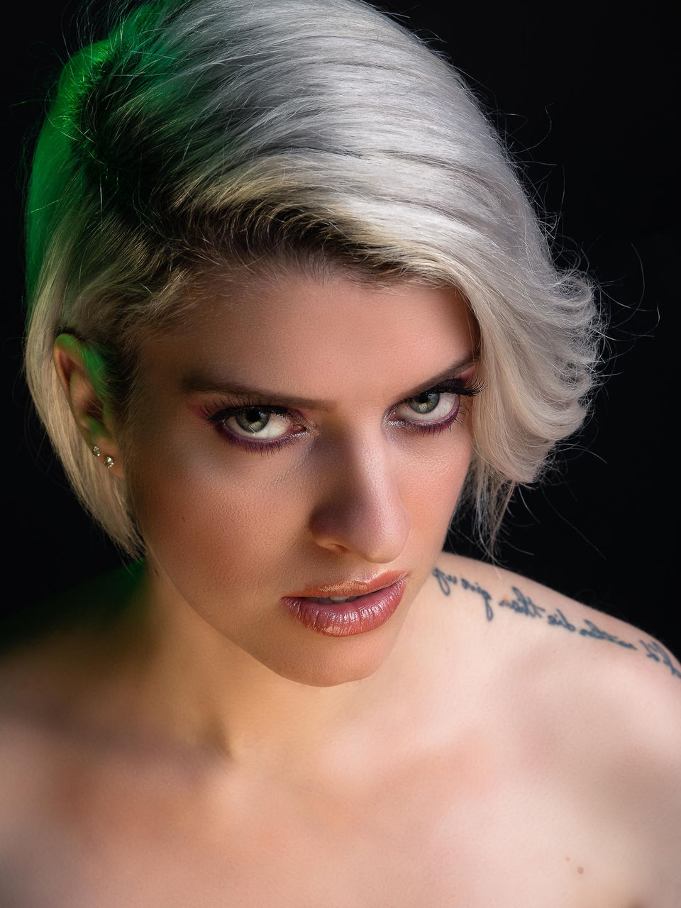 Beatrice looking the camera with a dramatic light goldish color