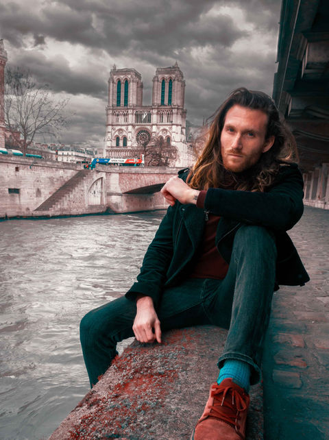 Notre Dame de Paris behind this man sit close to the PAris river
