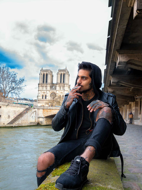 A man smoke a cigarette close to "Notre Dame de Paris"
