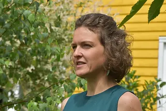 Judith Meinken im Profil vor gelbem Hintergrund draußen