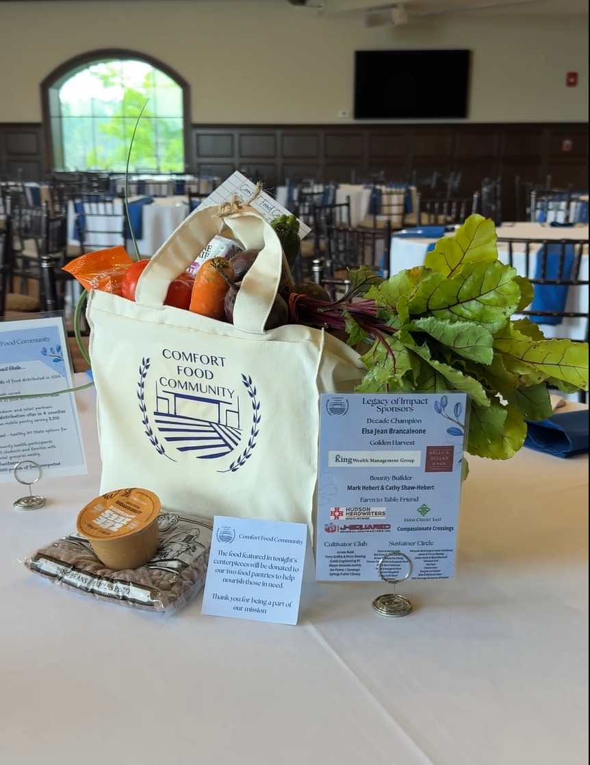 A cloth shopping bag filled with produce, and cards highlighting the event sponsors