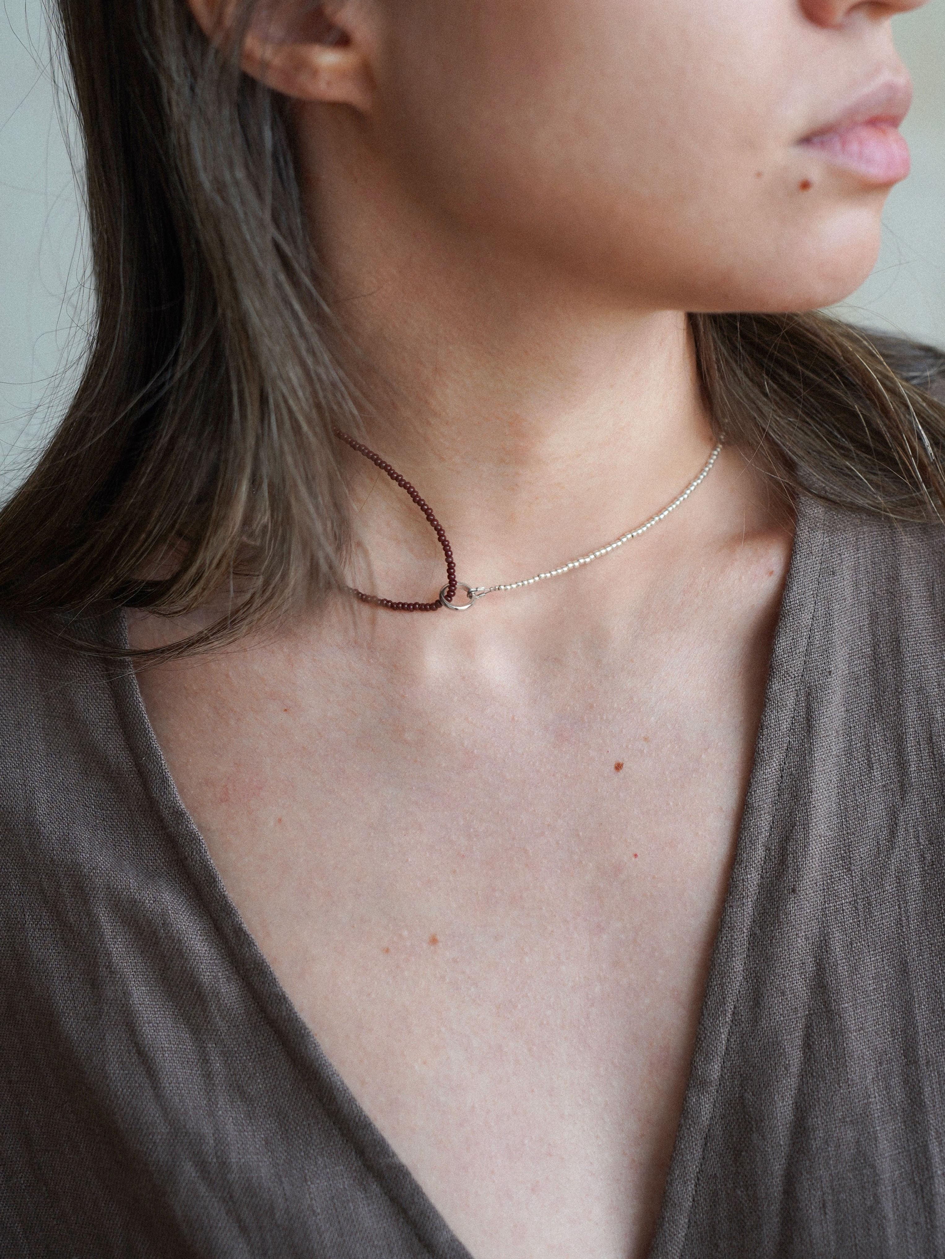 Asymmetrical beaded necklace with two colors and loop detail, perfect for everyday style