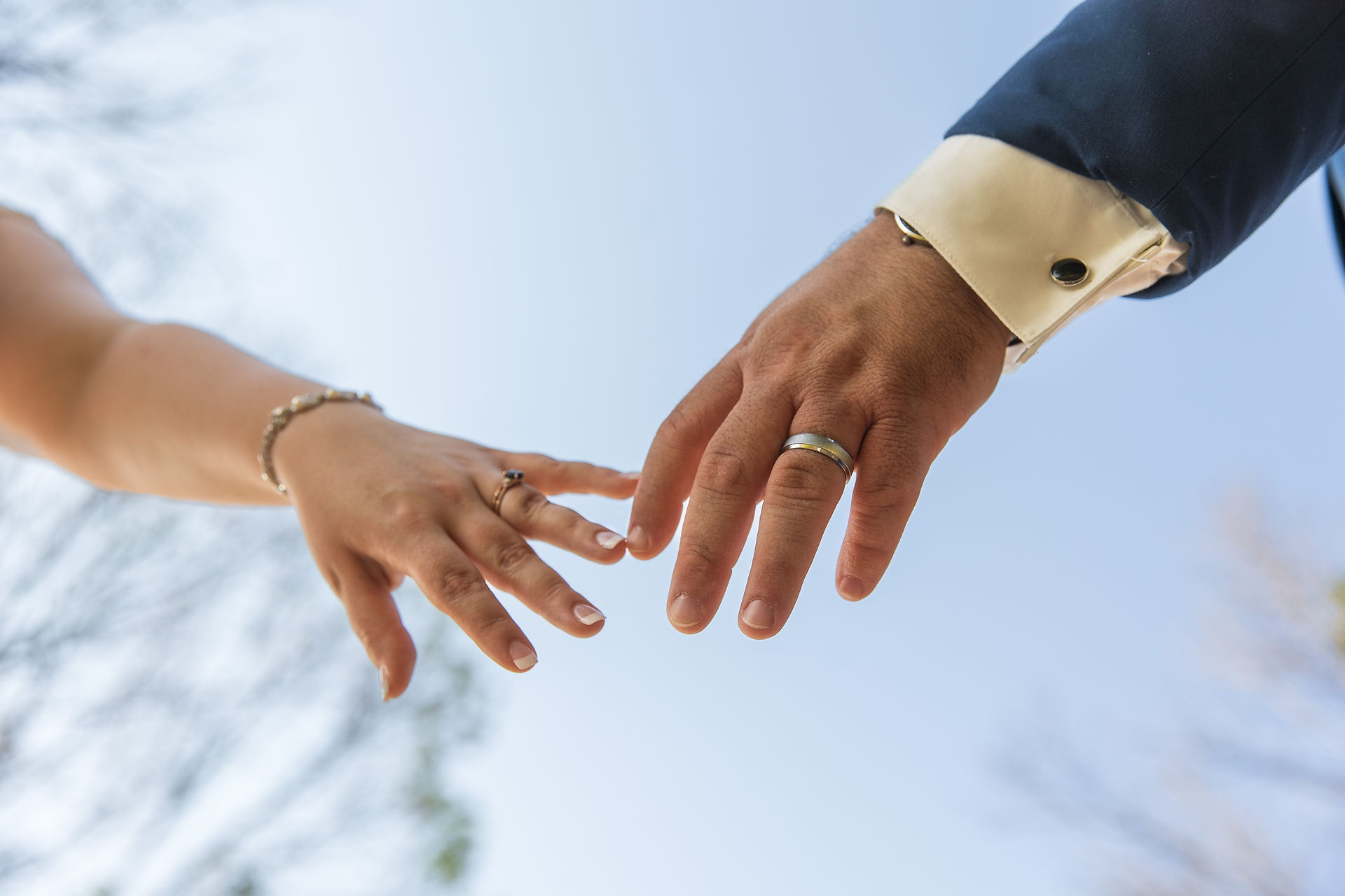 The bride and groom reach for each other with their wedding bands on at their Shreveport area summer wedding