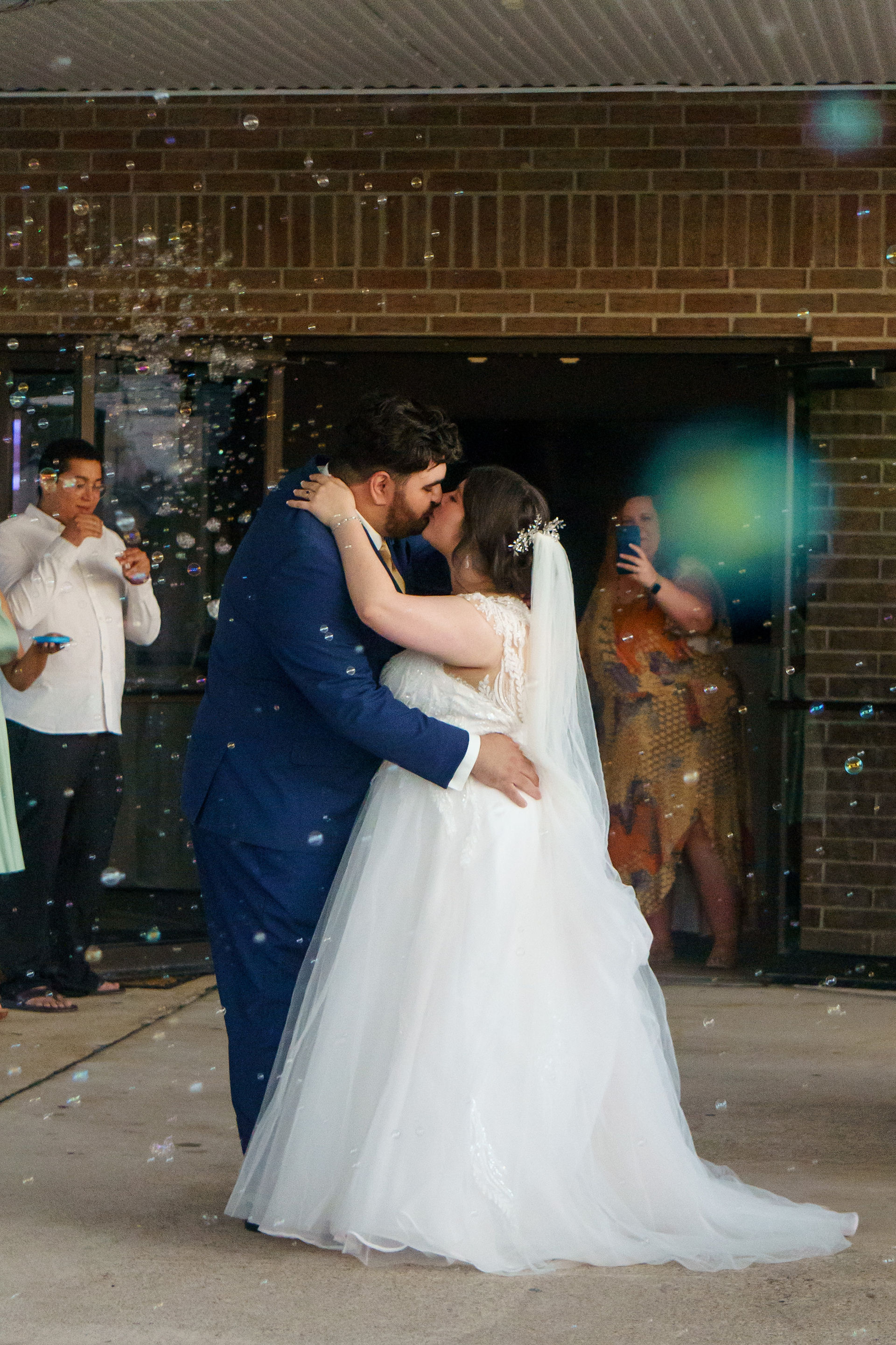 Kirsten and Vincent share a kiss during their grand exit from their wedding in Bossier City, Louisiana, photographed by Mary Cyrus Photography