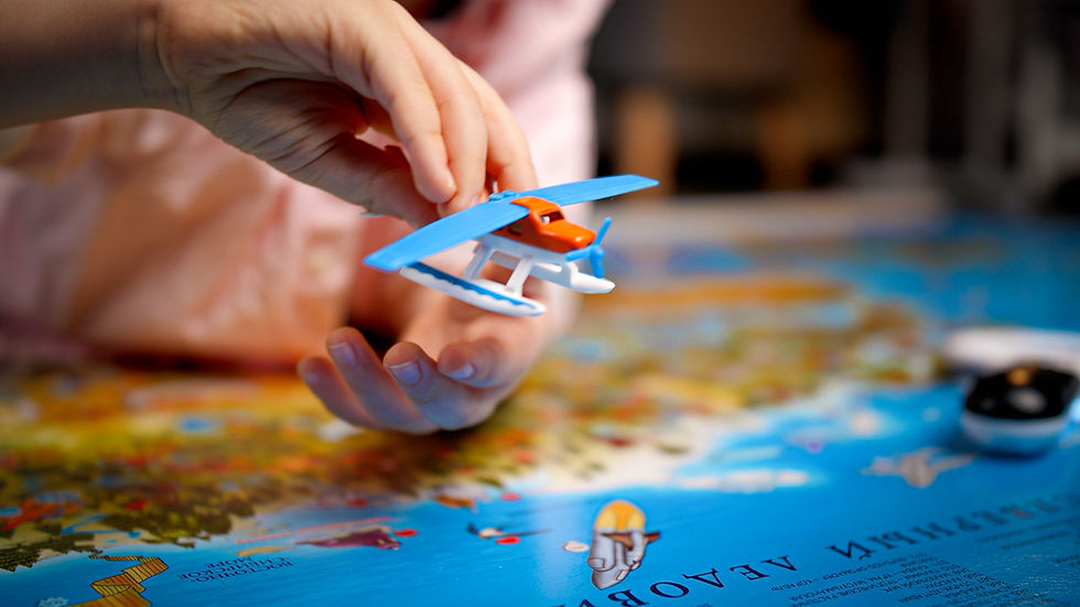 child playing with airplane and map