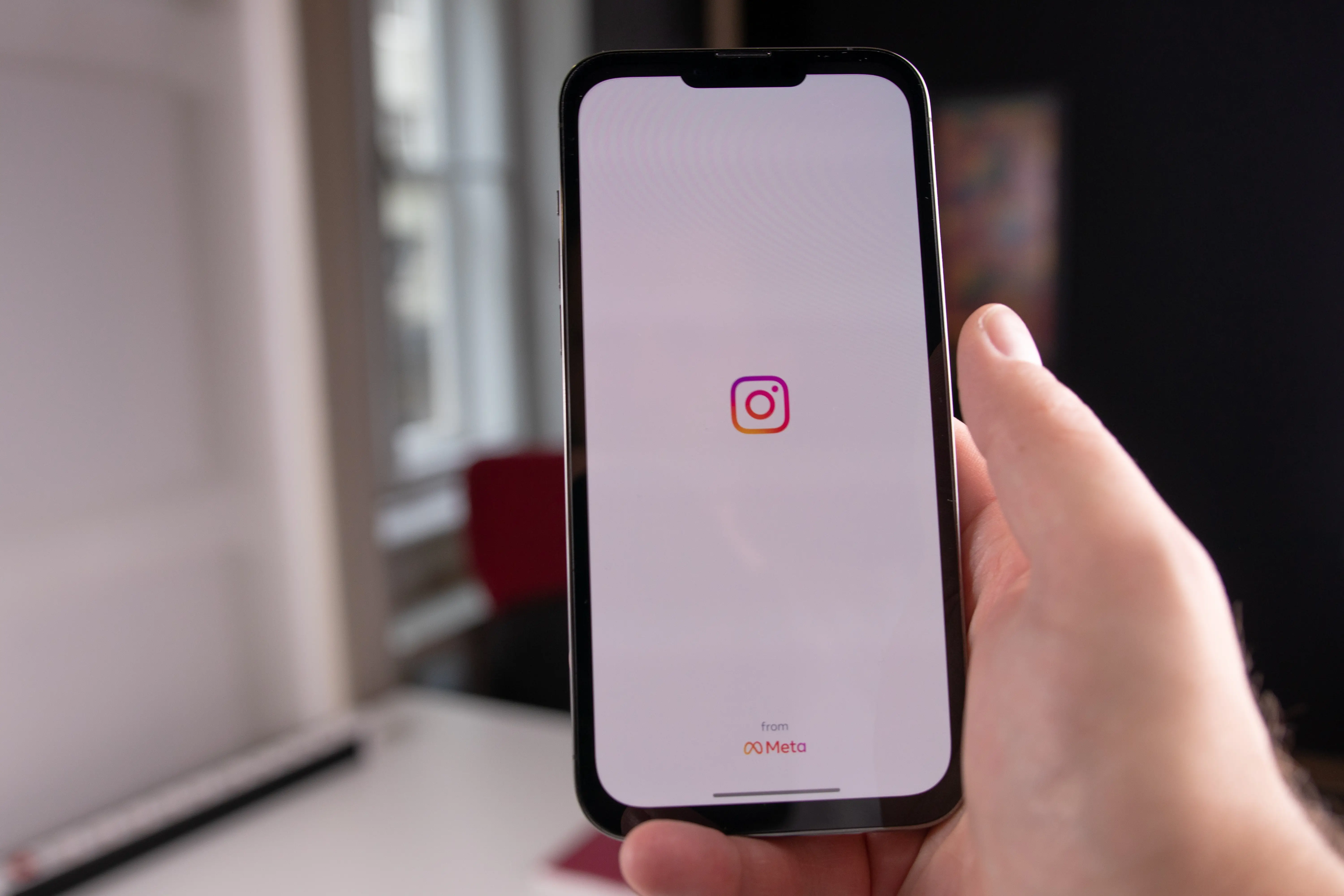 Pessoa segurando celular abrindo o instagram para postar +50 Ideias de Conteúdo para Instagram para Loja de Quadros Decorativos