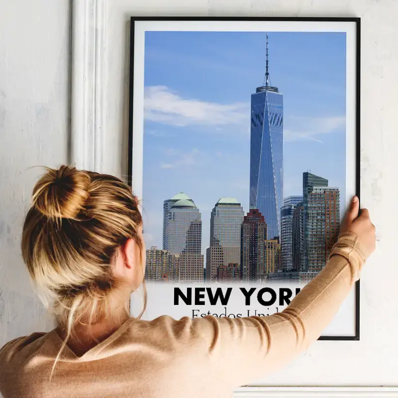 Mulher pendurando quadro com arte de Nova York com arte digital da Imprinté.