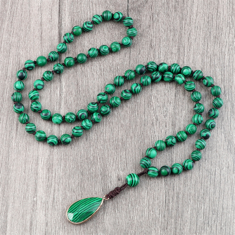 Hand-knotted malachite mala necklace laid flat