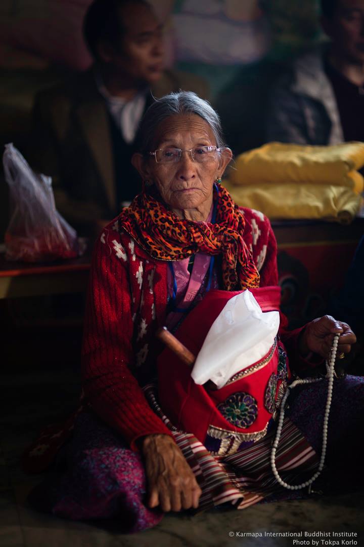 Elderly visitor holding a white ceremonial scarf and prayer beads — Monlam — March 2014 — Monlam 2013 Complete Collection — photograph by Tokpa Korlo