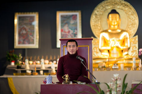 Quiet hands folded in prayer beneath warm temple light — Dhagpo Kagyu Ling, Dordogne, France — February 2015 — A Tara Morning — photograph by Tokpa Korlo