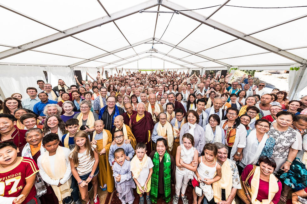 A large multigenerational group gathers closely together beneath a broad white event tent — Karma Migyur Ling, Montchardon, France — August 15, 2016 — Montchardon - Here's To 40 More Years! — photograph by Tokpa Korlo