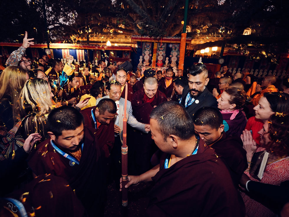 A dense evening crowd surrounds several central figures beneath glowing golden temple decorations — Bodh Gaya, India — Jan 9, 2025 — Monlam 2024 - The Gold Part 3 — photograph by Tokpa Korlo